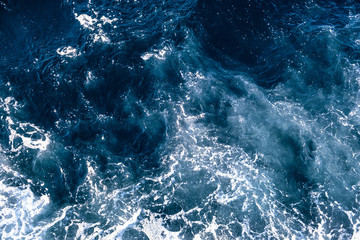 Top down aerial view of sea water surface. White foam waves texture as natural background. © bilanol