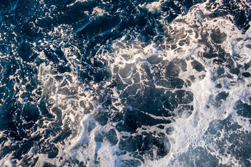Top down aerial view of sea water surface. White foam waves texture as natural background.