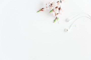 White flowering branch with headphones.White background.Copy space.Minimalist style.