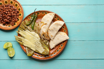 Mexican grilled nopal cactus with quesadillas and serrano chili peppers on turquoise background