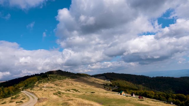 Time lapse of clouds flowing across the blue sky over the tops of the mountains.