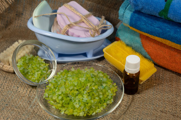 On the jute fabric are things for spa treatments - towels, sea salt, brushes, soap, essential oil.
