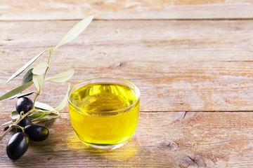 Close up of a glass bowl full of olive oil with olive brunch, healthy fats made in Puglia, Salento