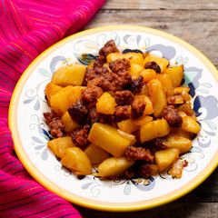 Mexican chorizo with potatoes on wooden background