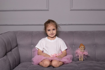 little girl ballerina is sitting and smiling