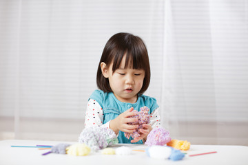 toddler girl learn making  Origami at home against white background