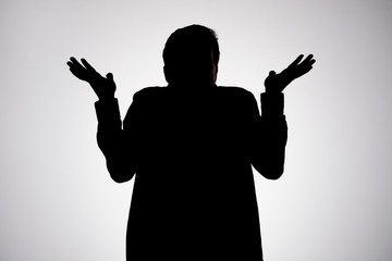 Man silhouette shrugging hands having no idea being confused