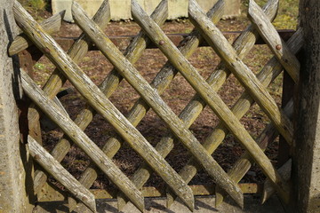 Wooden wattle fence in a garden near a rural house