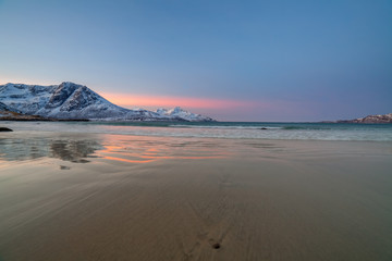 sunrise with amazing magenta color over sand beach and fjord. Tromso, Norway. Winter. Polar night. long shutter speed