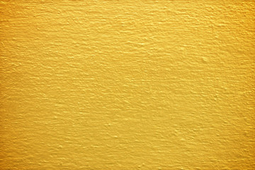 Gold paint on cement wall texture.
