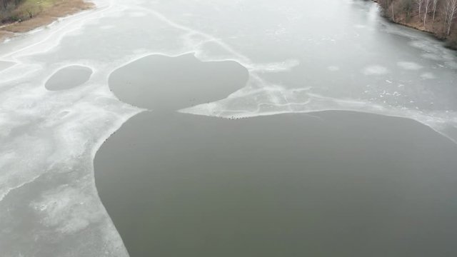 Flying above ice, top down aerial view of ice floes in the lake.