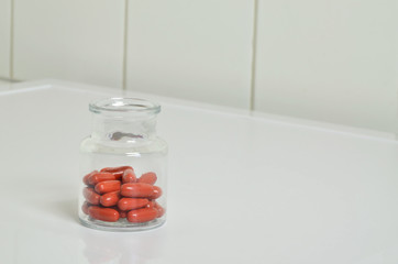 Red Pillsin a Vial, close up, isolated on white Background