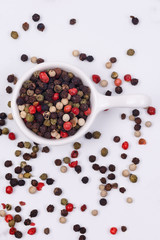 A mixture of multi-colored pepper in a small dish