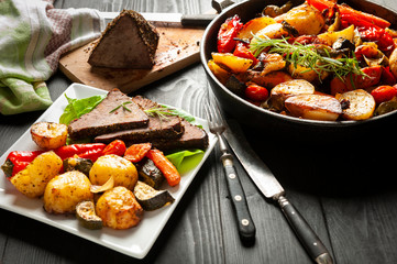 beef roasted in fresh herbs surrounded by baked vegetables