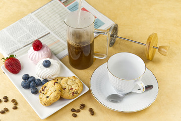 coffee cup with a gold border on olive wood board. Breakfast setting, coffee oatmeal cookies with raspberries and mini tosca cake