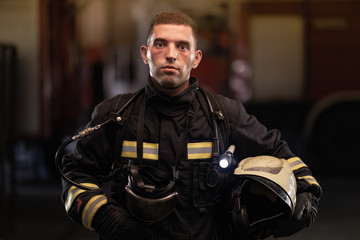 firefighter portrait wearing full equipment and emergency rescue equipment. taking off oxygen mask...