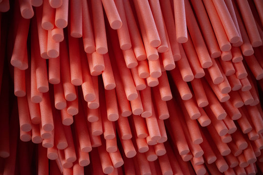 Abstract background of paralon tubes. Texture of red paralon cylinders. Technological picture of cut sausages from inorganic materials. Modern implementation of a minimalistic background.