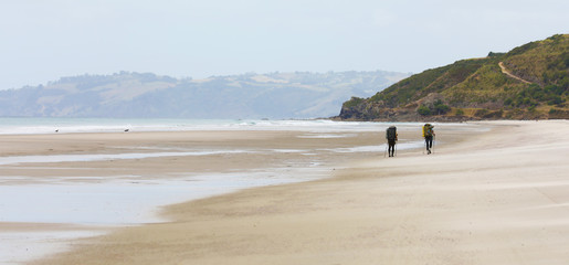 Pair of hikers on huge New Zealand beach