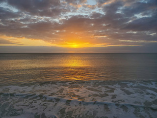 Obraz premium Abstract seascape panoramic background - Orange color in the sky, sunset late afternoon. Calm seas/ocean in the bottom of the frame. Minimalistic simple background image, blue and yellow colors.