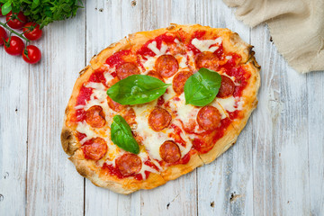 Pepperoni pizza on Roman dough pinsa on white board