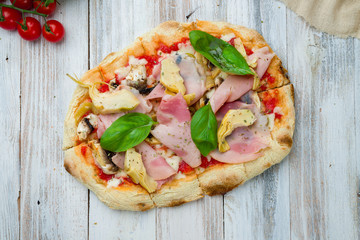 Roman pizza with ham and artichokes on Roman dough, pinsa