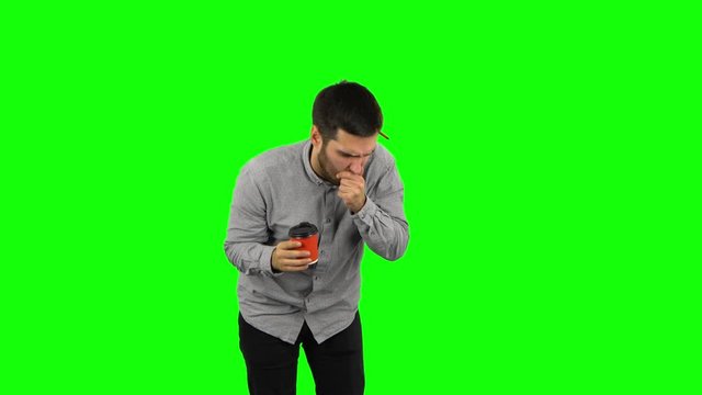 Brunette guy drinking unpalatable coffee and is disgusted. Green screen