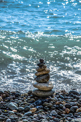  Seascape, pebble beach pyramids on the seashore. Travel and adventure.