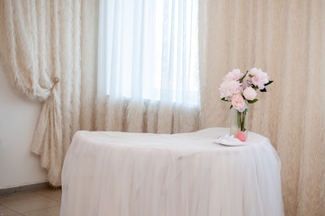 White table with bouquet of flowers in vase