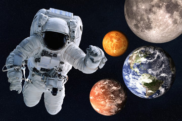 Fototapeta na wymiar Astronaut near Planets of solar system together in space. Earth, Mars, Venus, Moon. Science fiction wallpaper. Elements of this image were furnished by NASA.
