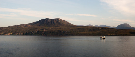 Fishingboat at sea in front of Mountains, Scotland