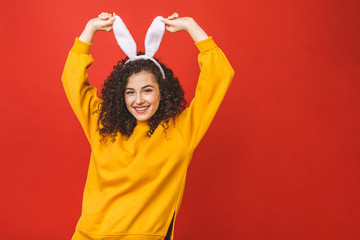 Young caucasian woman wearing cute easter rabbit ears over red isolated background while smiling...