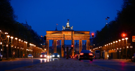 Brandenburg Gate at Night, Berlin, Germany. The center of the road, passing by the blurred cars. View from the west side of Berlin (Road side view). German name is Brandenburger Tor.  © Kost9