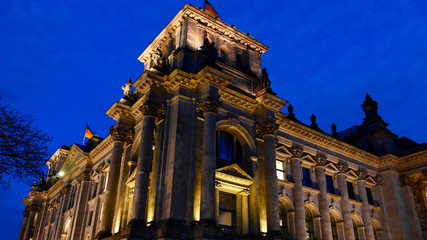 Fototapeta na wymiar Reichstag (Deutscher Bundestag) with golden lighting at night. Famous Reichstag building, seat of the German Parliament .Central Berlin Mitte district.