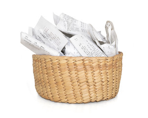 Obraz premium Stuffed storage basket of receipts for filing taxes and deductibles. Straw container with many crumbled papers. Isolated on white.