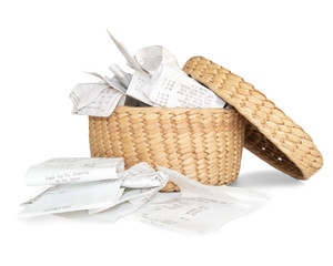 Overfilled storage basket of receipts for filing taxes and deductibles. Straw basket with many...