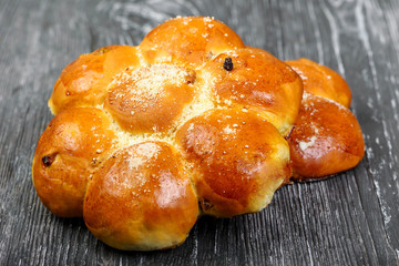 Sweet 7 flower-shaped buns with raisins with a sprinkle on a gray wooden background