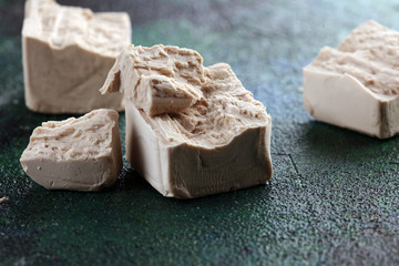 Dry yeast crumbled and yeast block for baking on background