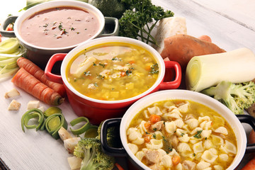 Set of soups from worldwide cuisines, healthy food. Broth with noodles, beef soup and broth with marrow dumplings. All soups with healthy vegetables on table - obrazy, fototapety, plakaty