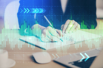 Forex graph on hand taking notes background. Concept of research. Multi exposure