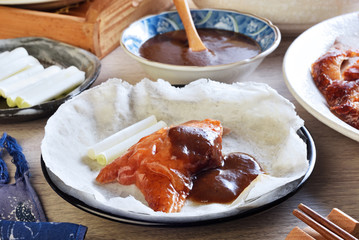 Peking roast duck served with  spring onion and  sauce on pancakes.  