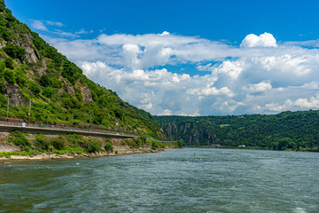 Obraz premium Germany, Rhine Romantic Cruise, a large body of water with a mountain in the background