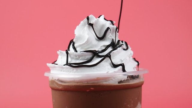 Chocolate sauce topped whip cream Cocoa smoothie on pink background, Food concept Front view.
