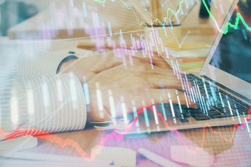 Multi exposure of stock market graph with man working on laptop on background. Concept of financial analysis.