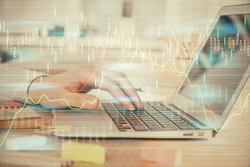 Double exposure of stock market graph with man working on laptop on background. Concept of financial analysis.