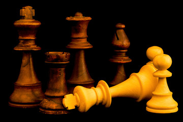 White team surrender to Black team at the end of the game. Two standard chess wooden pieces on black background