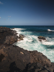 Fototapeta na wymiar waves crashing on rocks near coastline of island in Kauai, Hawaii