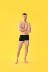 Fototapeta premium Handsome man in underwear on color background