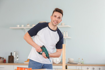 Young man assembling furniture at home