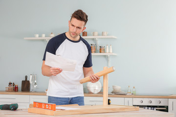 Young man assembling furniture at home