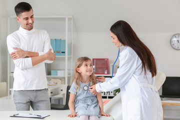 Man with little daughter visiting pediatrician in clinic